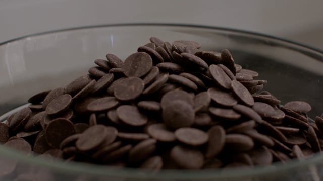 Delicious chocolate chips are poured into a mixing bowl.  