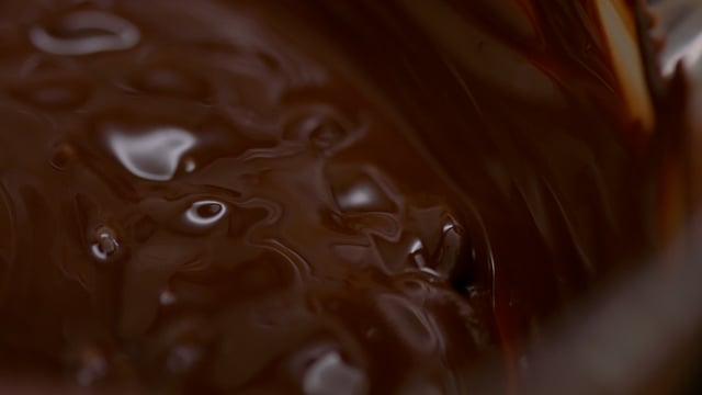 Decadent melted chocolate being mixed in a mixing bowl. 