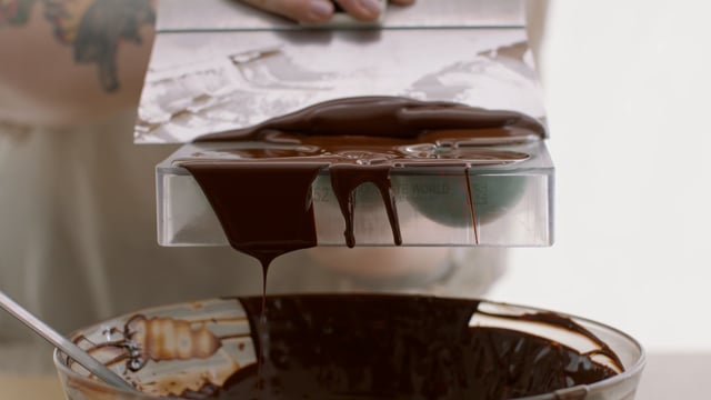 Pouring melted chocolate into a mould. Designer desserts. Luxury chocolate making. 