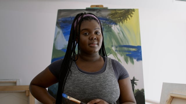 Portrait of a young black female artist in her studio. 