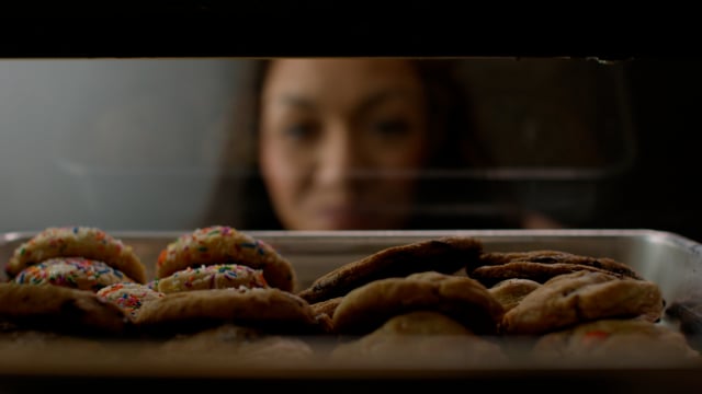 Young woman trying to decide which delicious cookie to choose. 