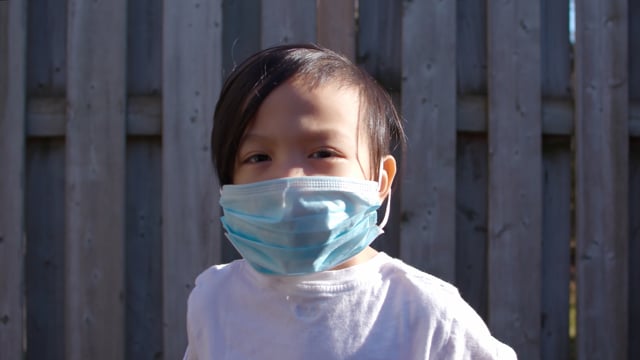 Young boy wears a mask due to covid-19 health crisis.