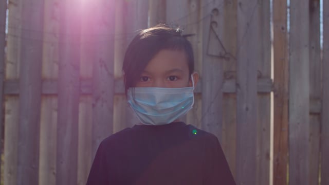 Young Asian boy wears a mask due to COVID-19 health crisis.