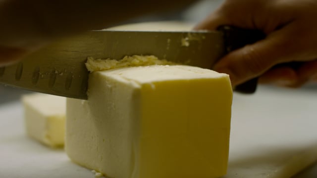 Baking prep. Cutting sticks of decadent butter.