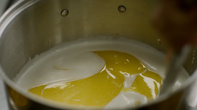 Stirring a big pot of melted butter. Kitchen prep.  