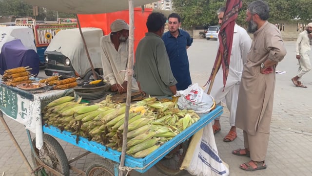 Men talking at a food cart