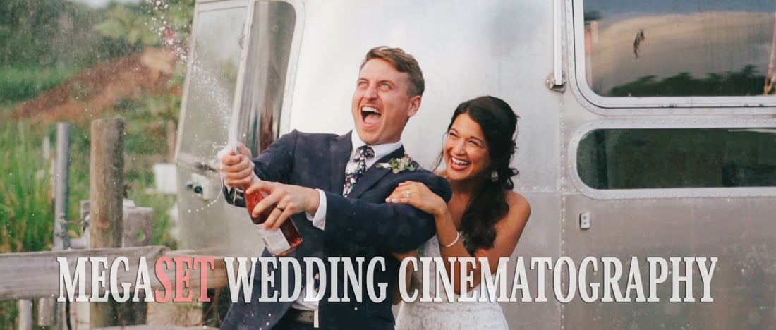 Bride and groom laughing as they open champagne