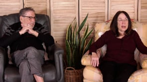 George and Linda Pransky sitting in chairs and talking to an audience. 