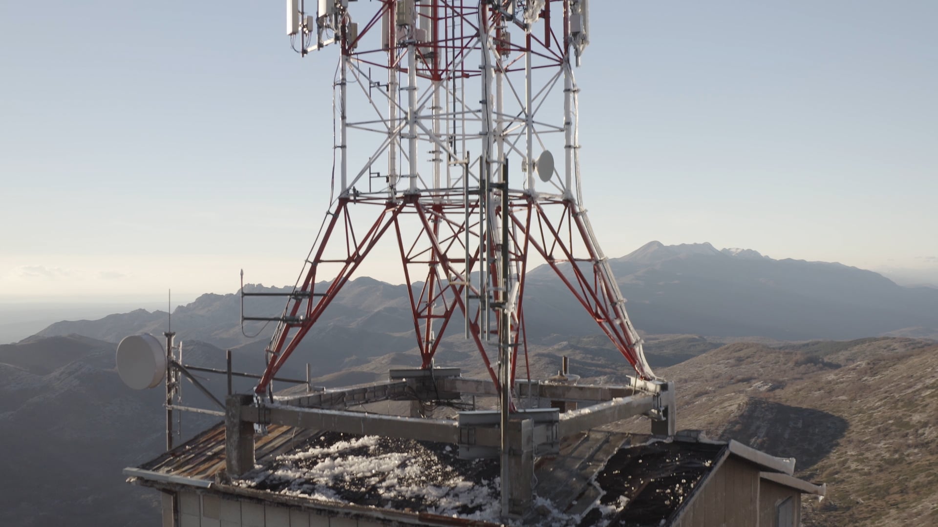 Small antenna on the roof of the house, fade out to mountain view