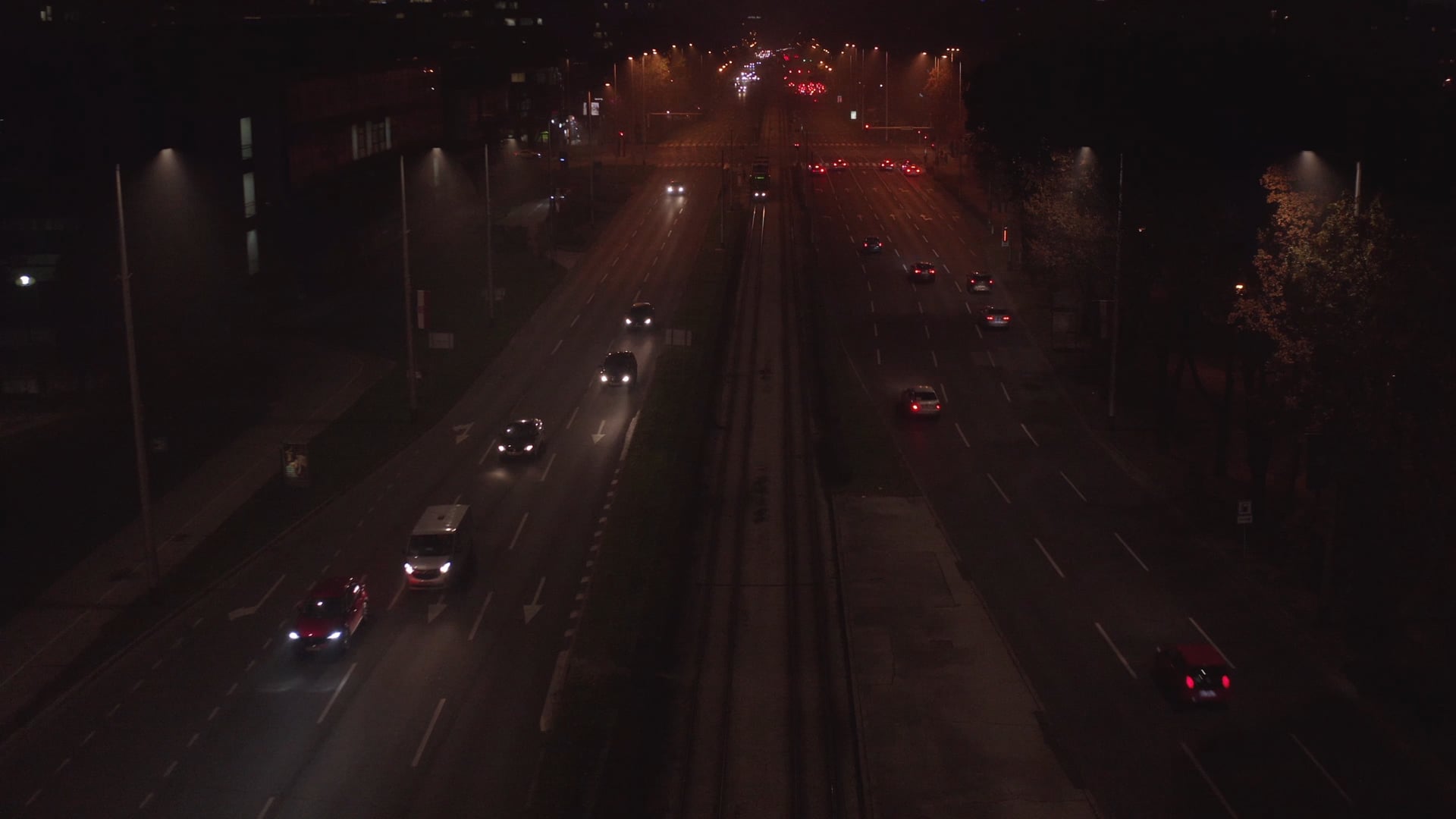 Slowly descending shot, night traffic, tram waiting on the tram station