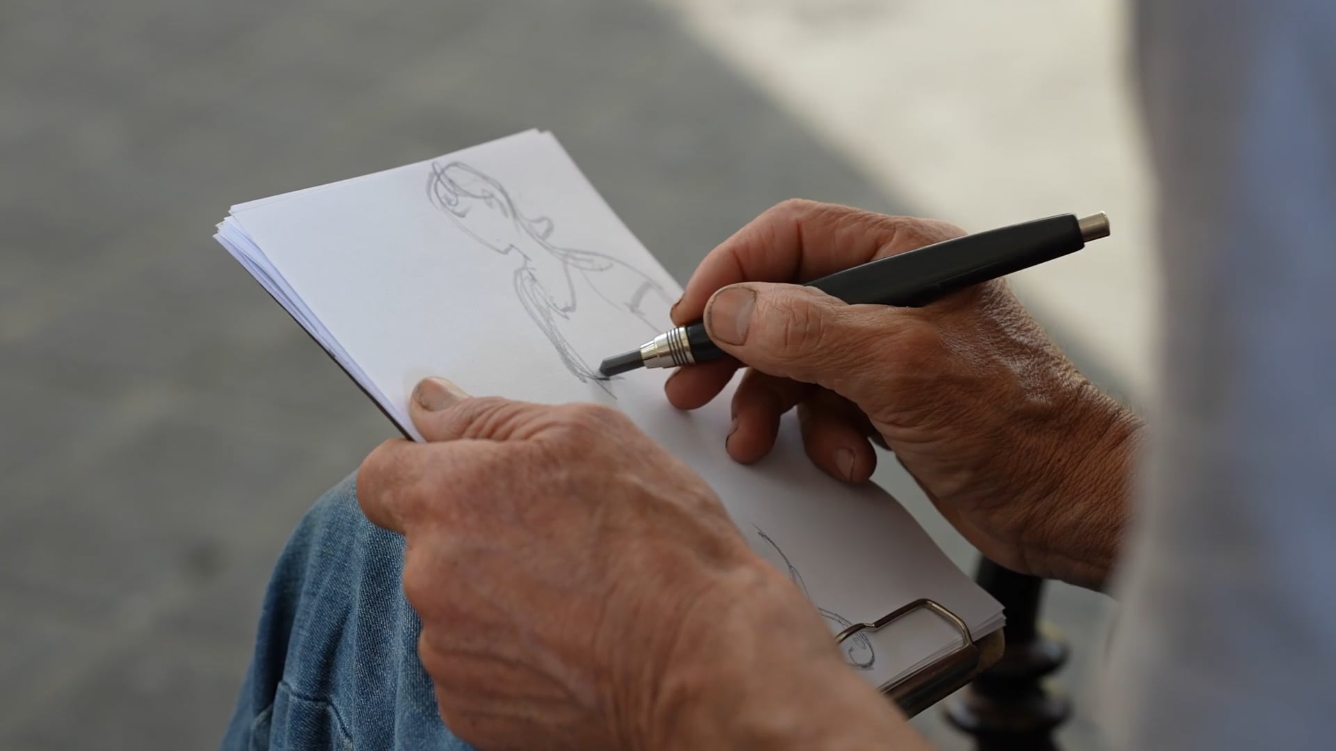 Older man doing a quick sketch, close up