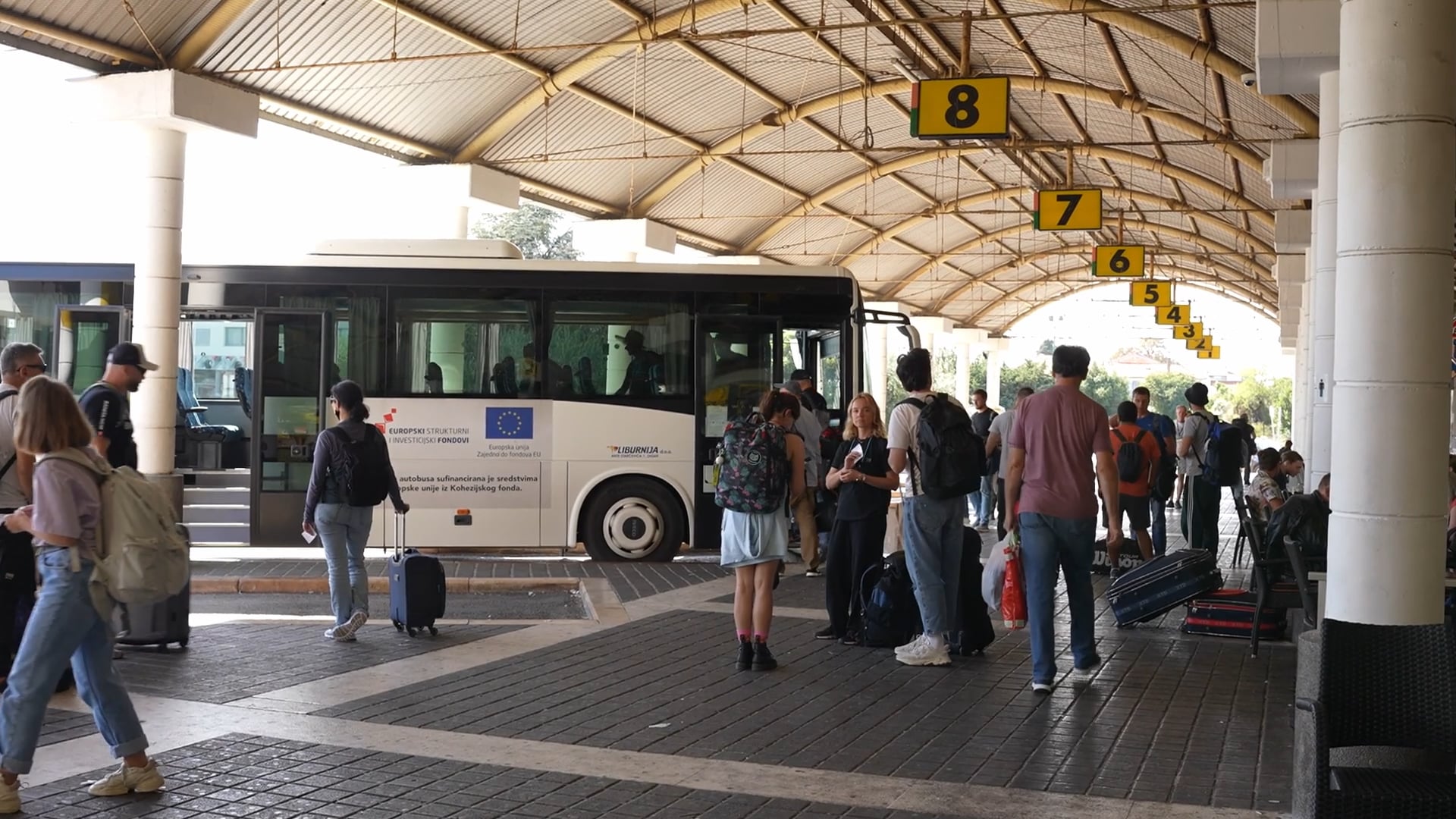 People waiting and passing by on the bus terminal