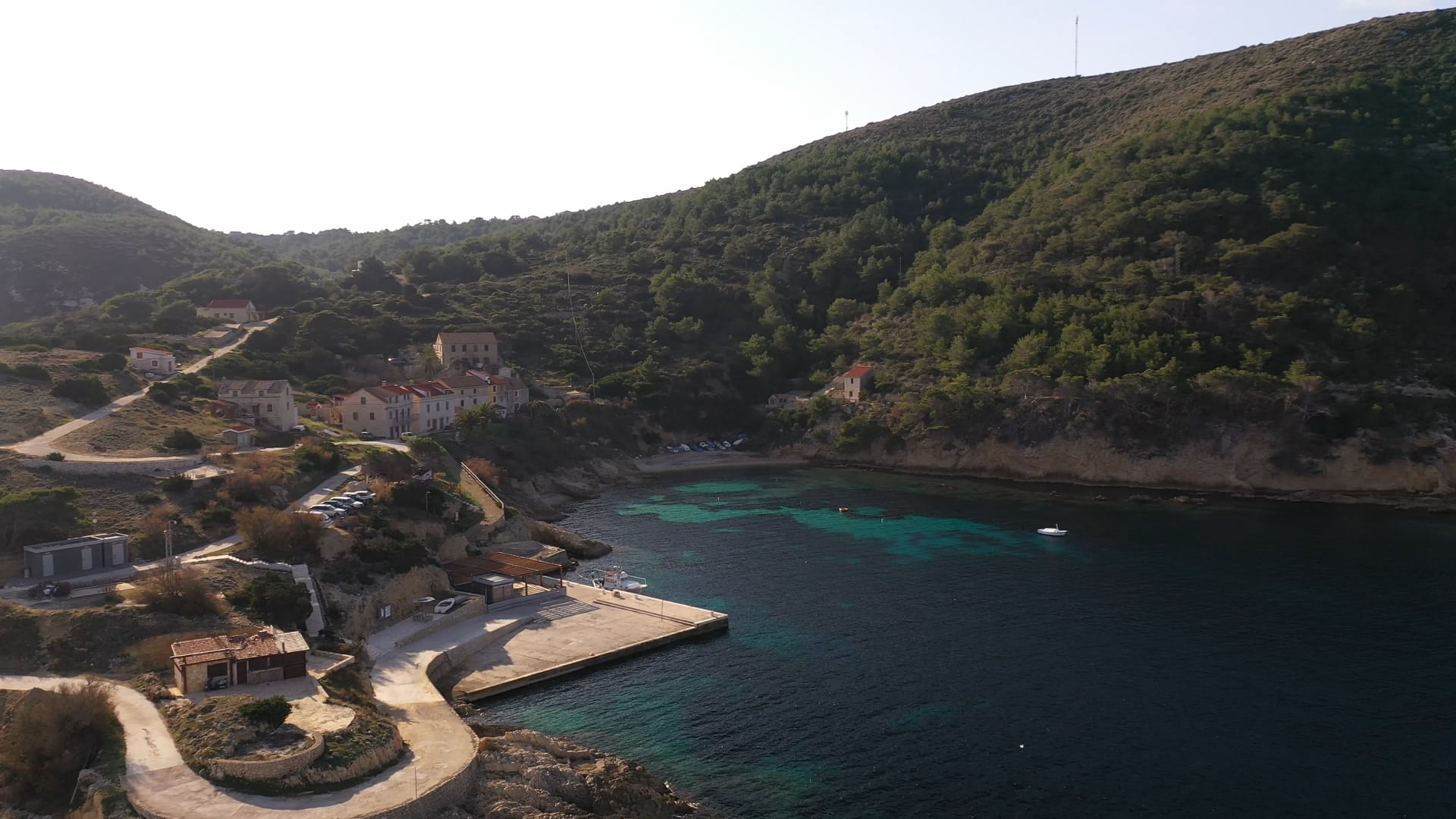 Beautiful small bay wiht few houses, crystal clear and dark blue sea, sunshine