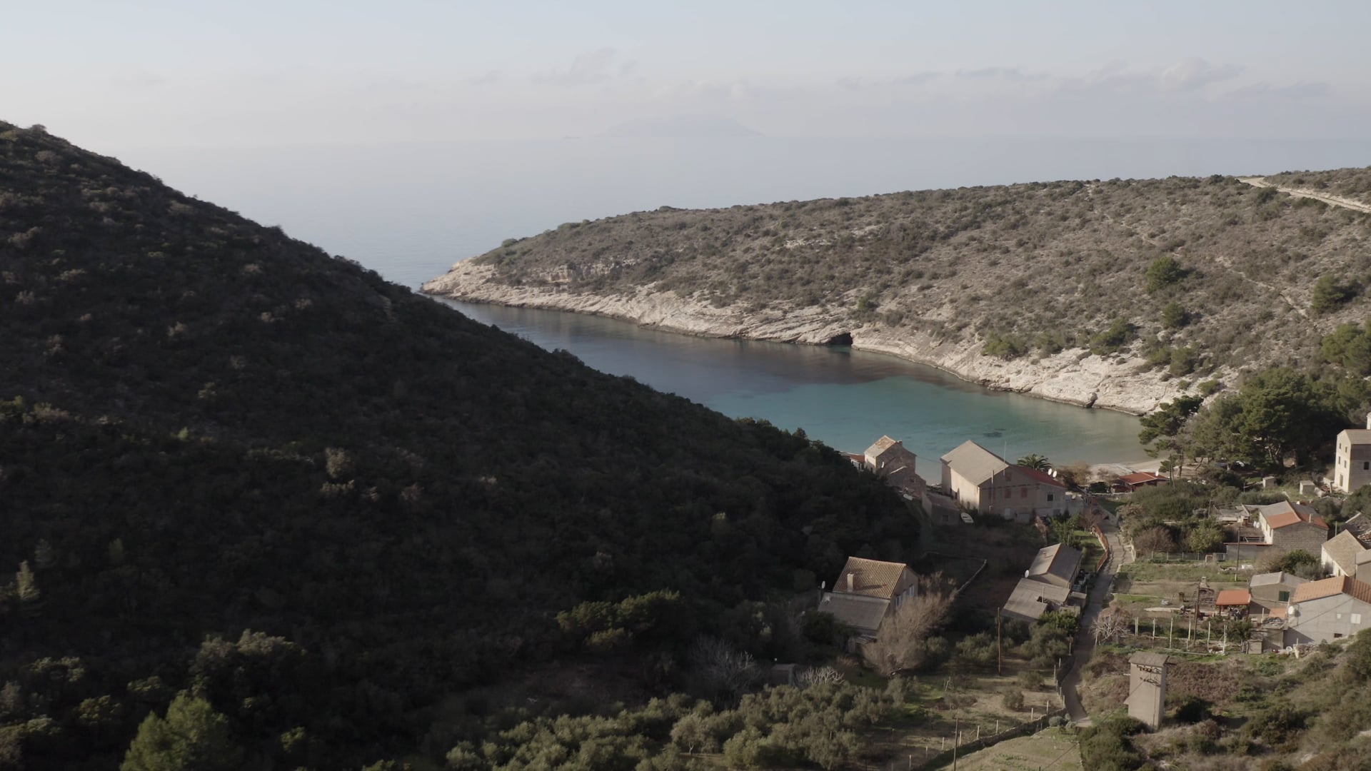 Crystal clear blue sea, small beach, few houses