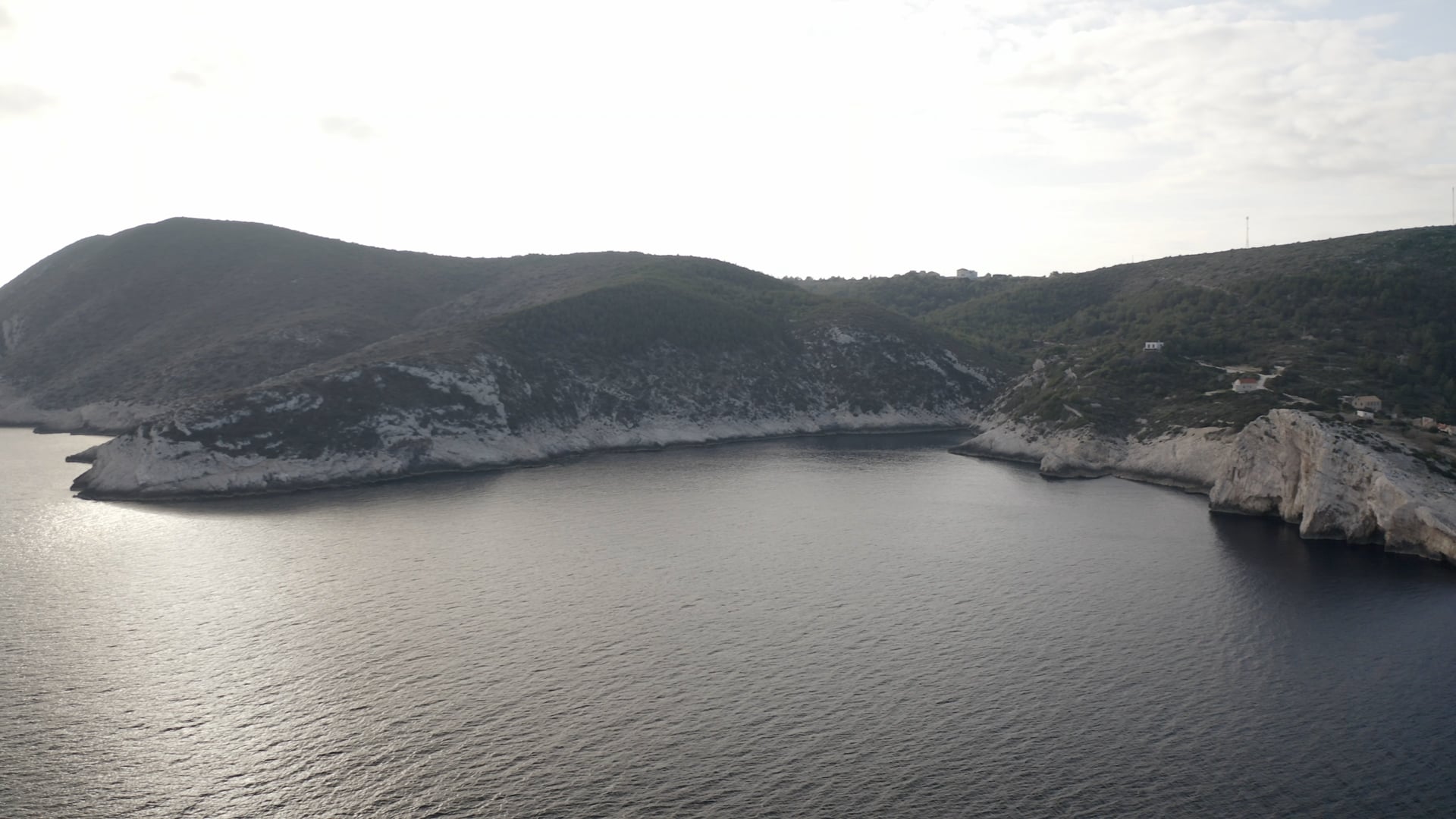 Approaching the cliff near the sea and the forest, few houses visible