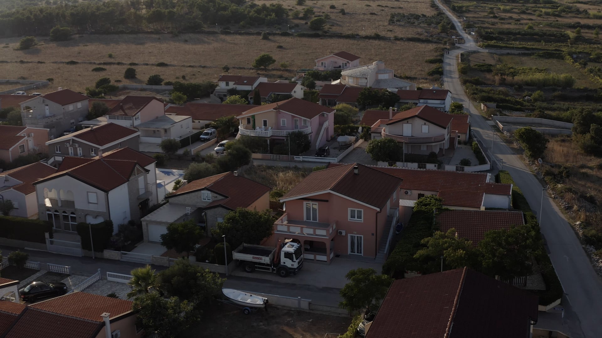 Flying above houses, road visible at the beginning, forest visible later