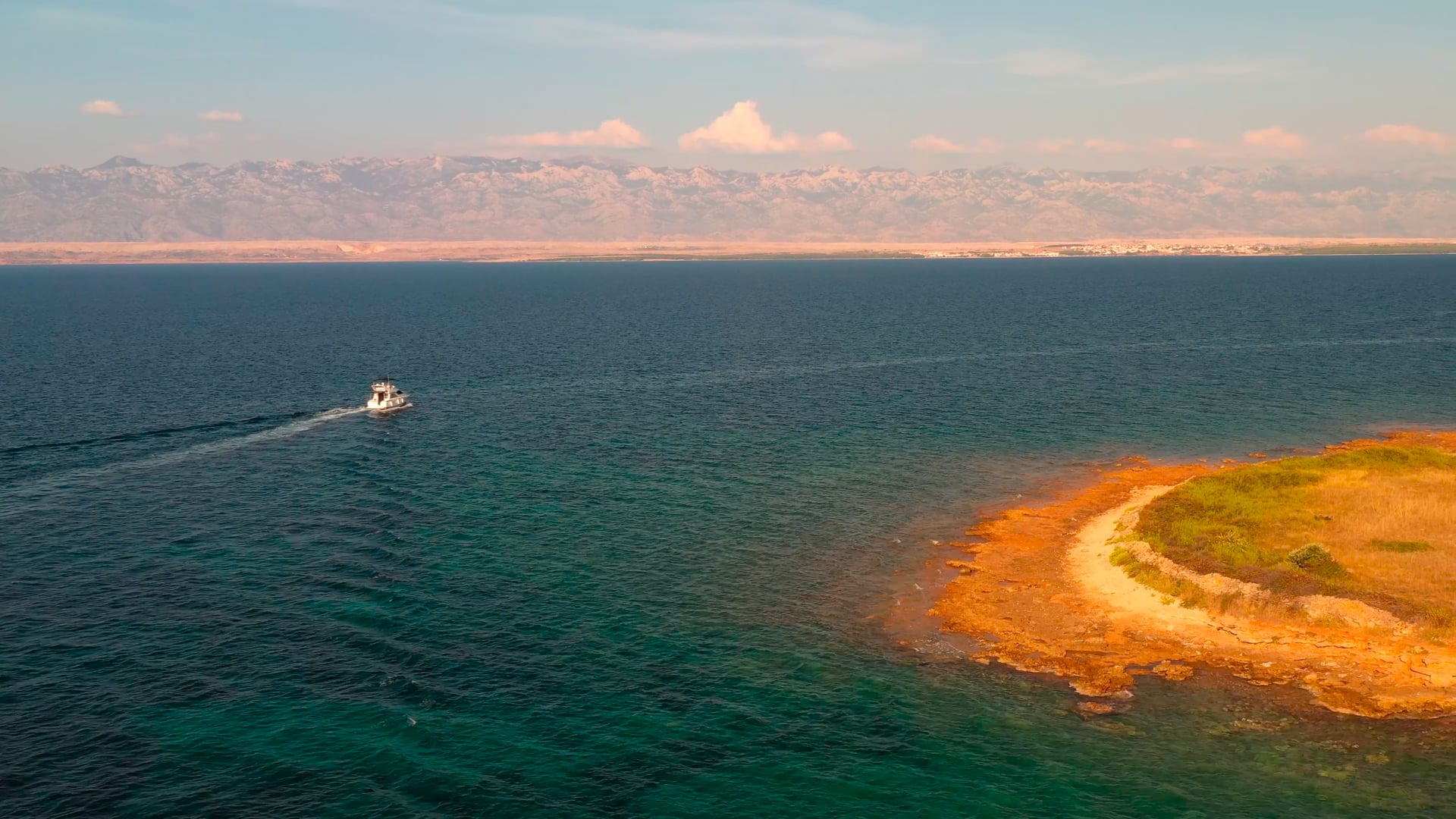 Small boat near the coast, mountain in the distance