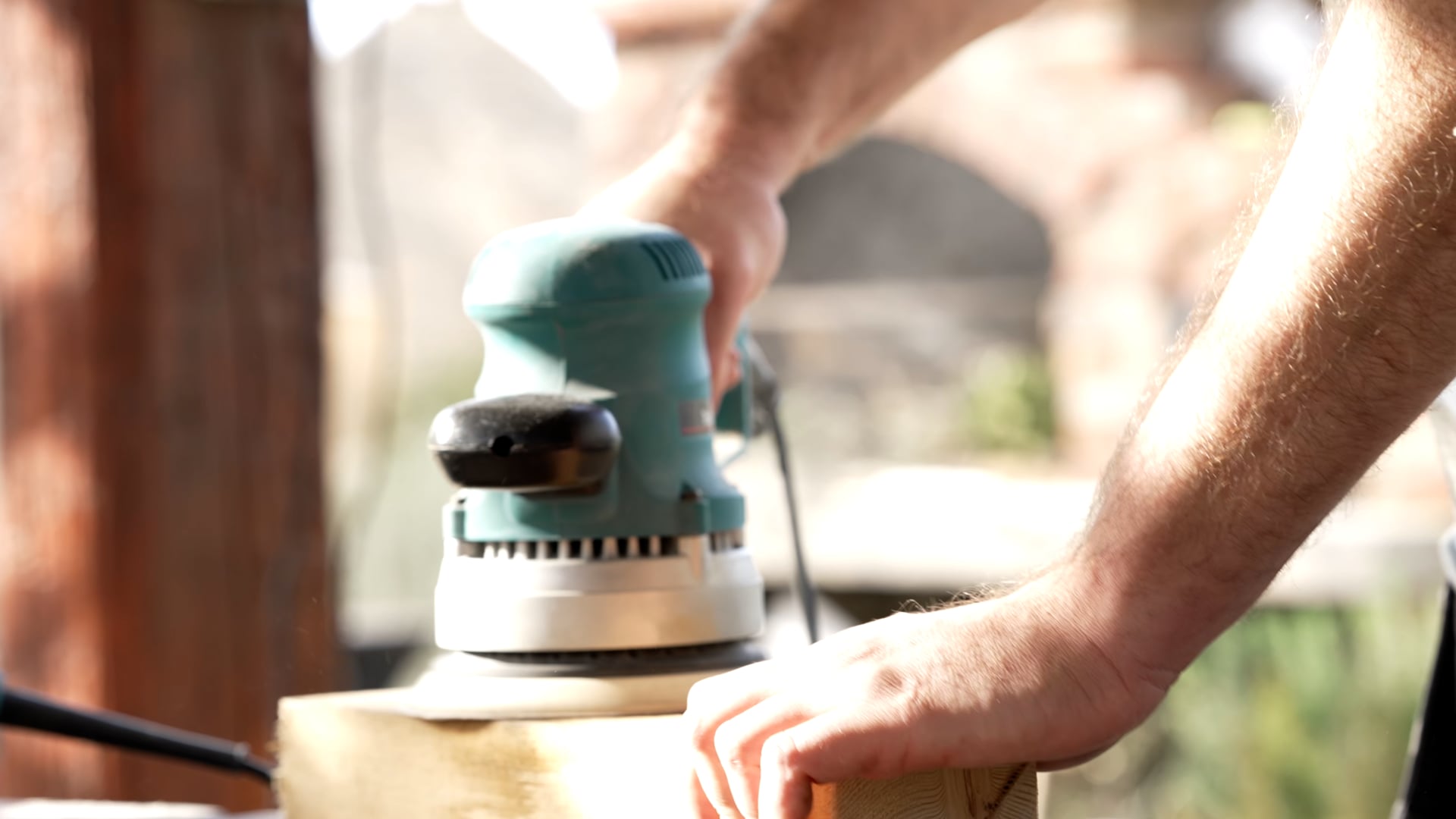 Man sanding a wooden block, extended shot