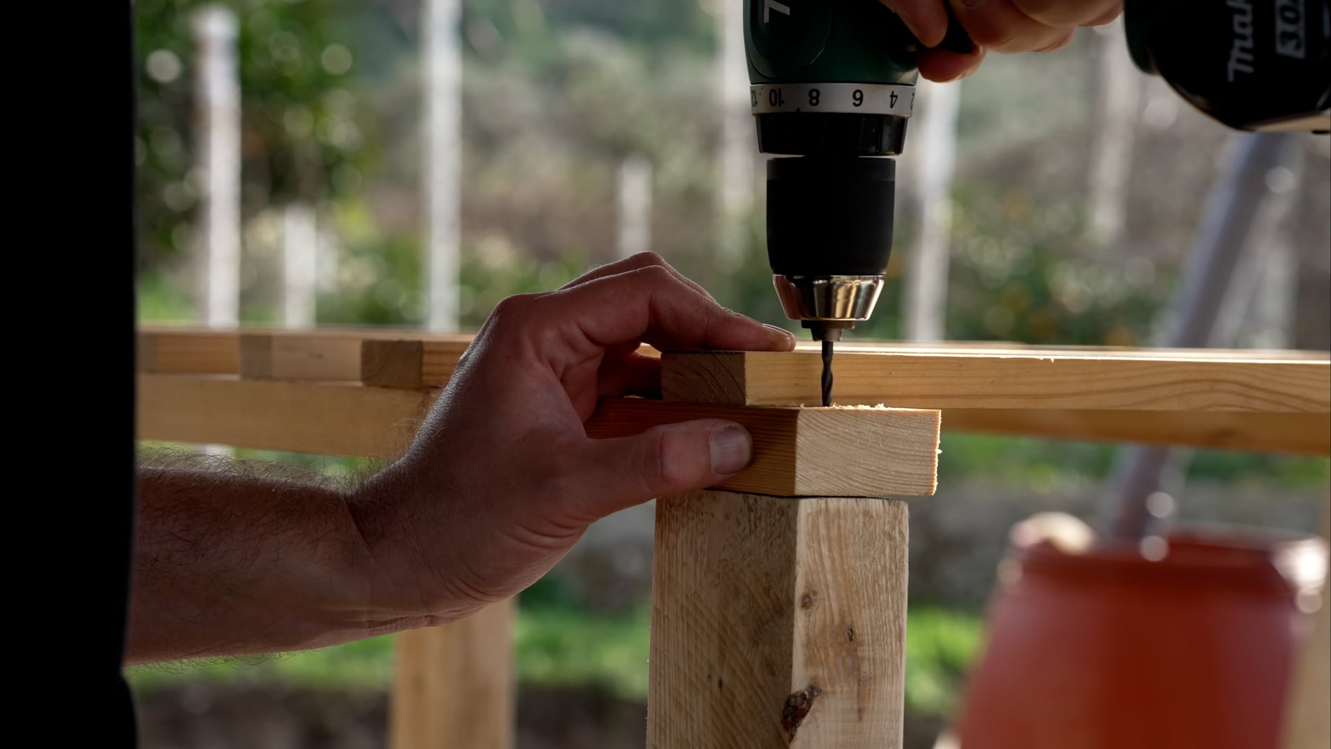 Man using a handdrill, wooden construction
