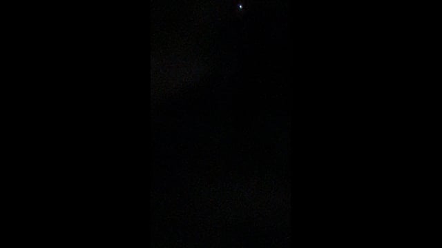 A small white light near the top of a dark night sky in Cabo San Lucas.