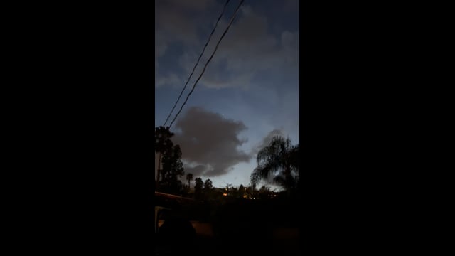 Clouds and evening sky above trees and overhead wires in Woodland Hills.