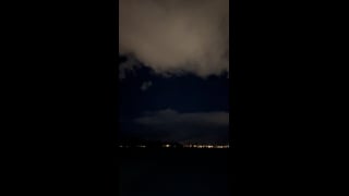Broad clouds above a dark landscape and distant lights in La Quinta.