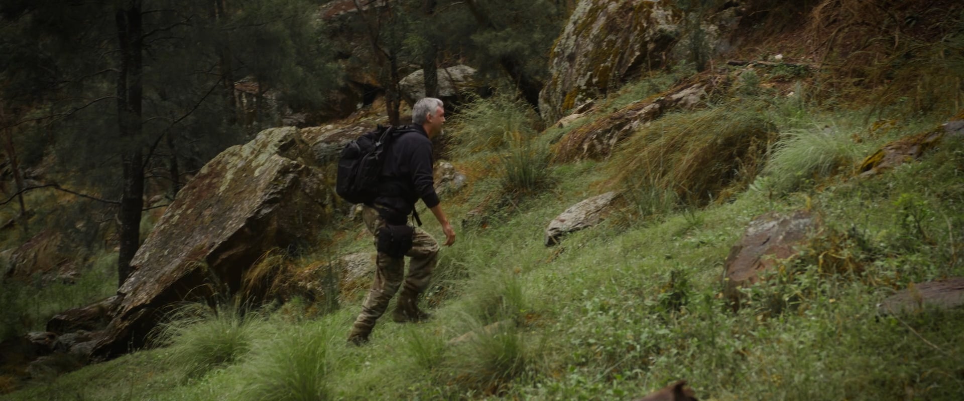 Hiker climbing a rocky, grassy slope, a still from Mustard Design & Digital's 2024 video showreel