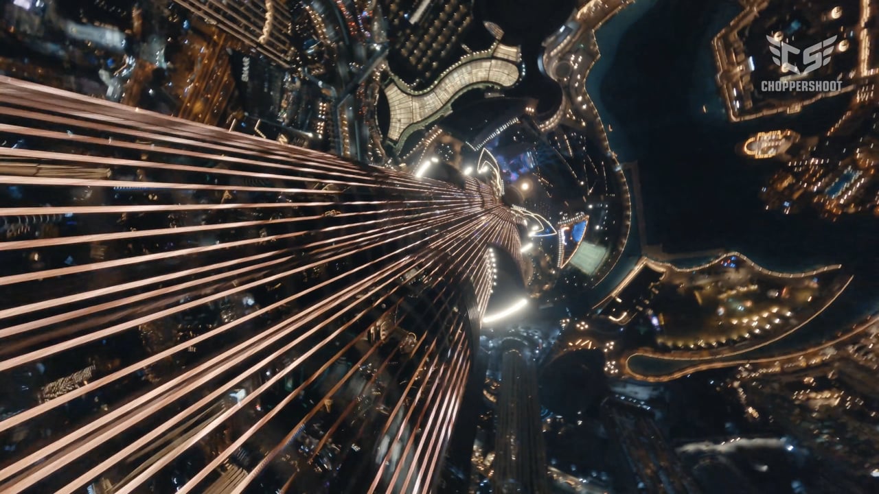 FPV drone diving down the Burj Khalifa towards the lights of Downtown Dubai