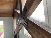 A wooden beam with a cross in a pest-free barn