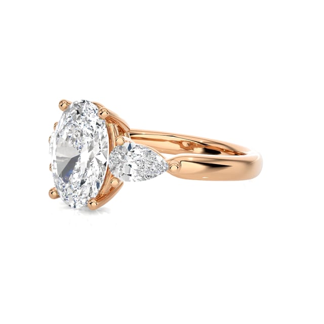 One of a kind trilogy ring with a 3.00 carat oval diamond with side pear diamonds of 0.35 carat each in red gold