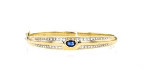 C. 1980 Vintage .75 Carat Sapphire and 1.00 ct. t.w. Diamond Bangle Bracelet in 18kt Yellow Gold