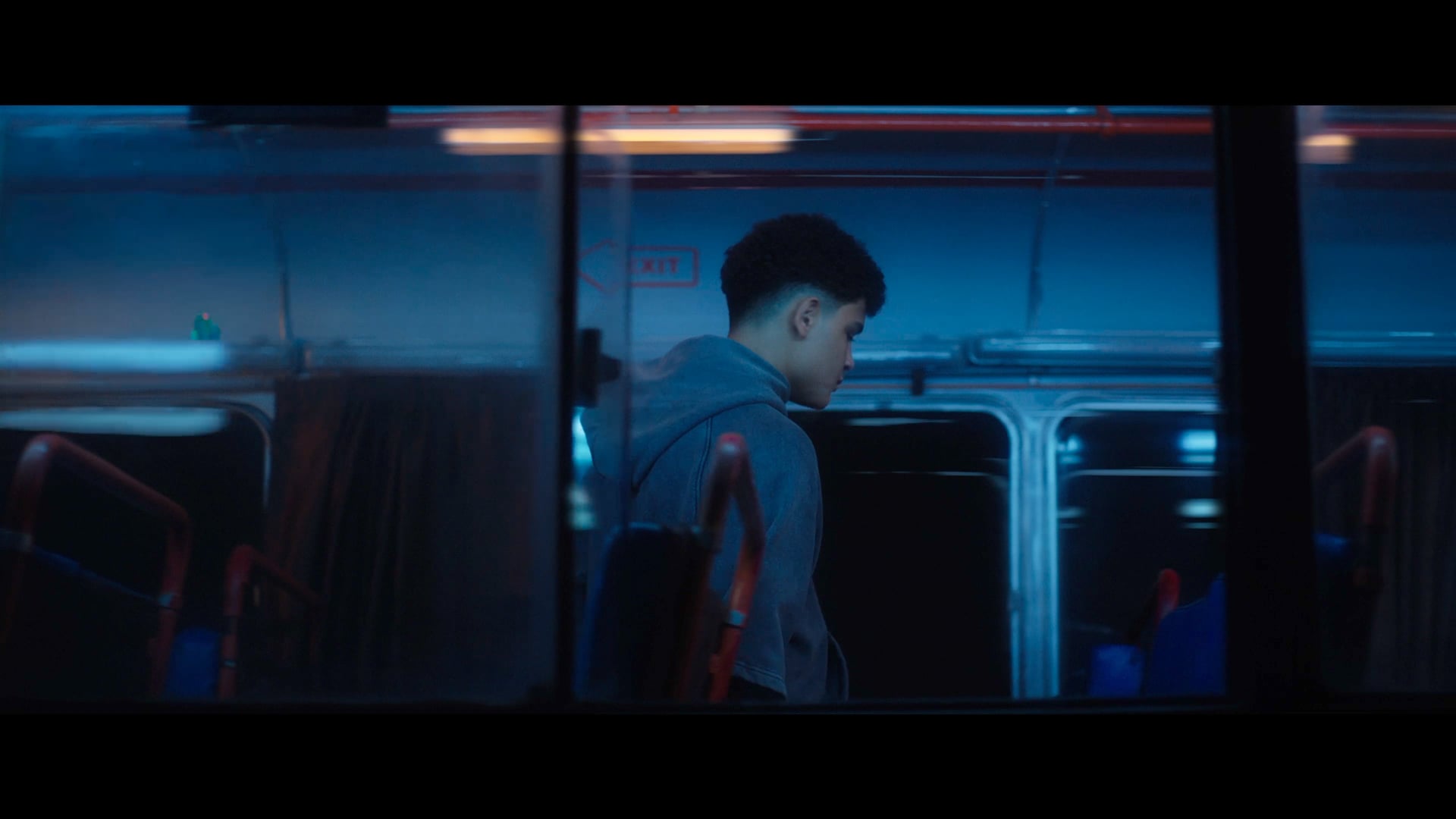 Still from MC Abdul, I May Be Young: a young man alone on a night bus