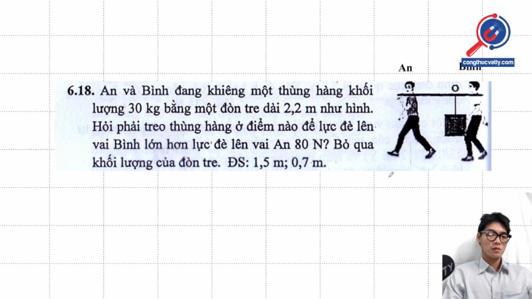 An và Bình đang khiêng một thùng hàng khối lượng 30 kg bằng một đòn tre dài 2,2 m như hình. Hỏi phải treo thùng hàng ở điểm nào để lực đè lên vai Bình lớn hơn.