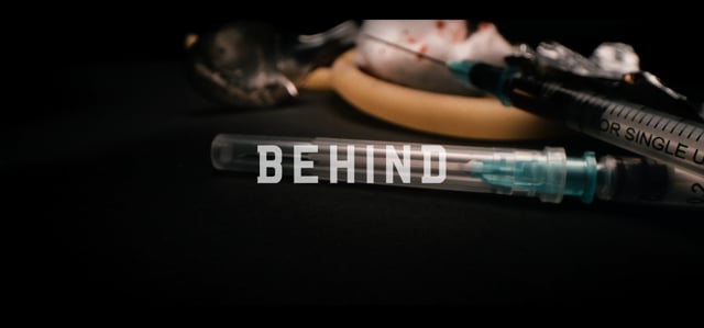 BEHIND
