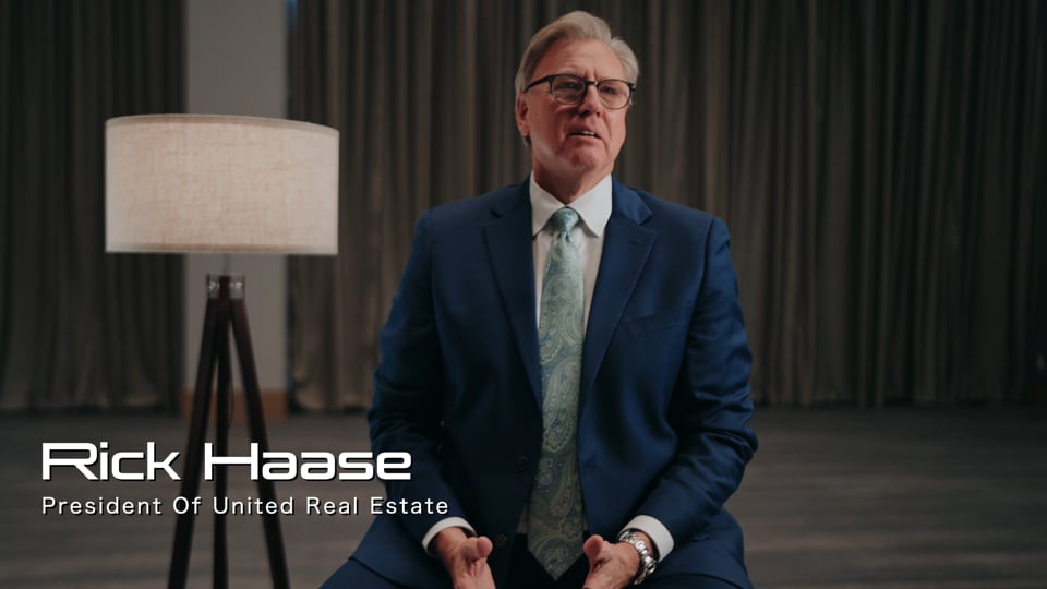 Professional interview video production setup in Dallas with camera, lighting, audio gear, and seated subject in a modern office.