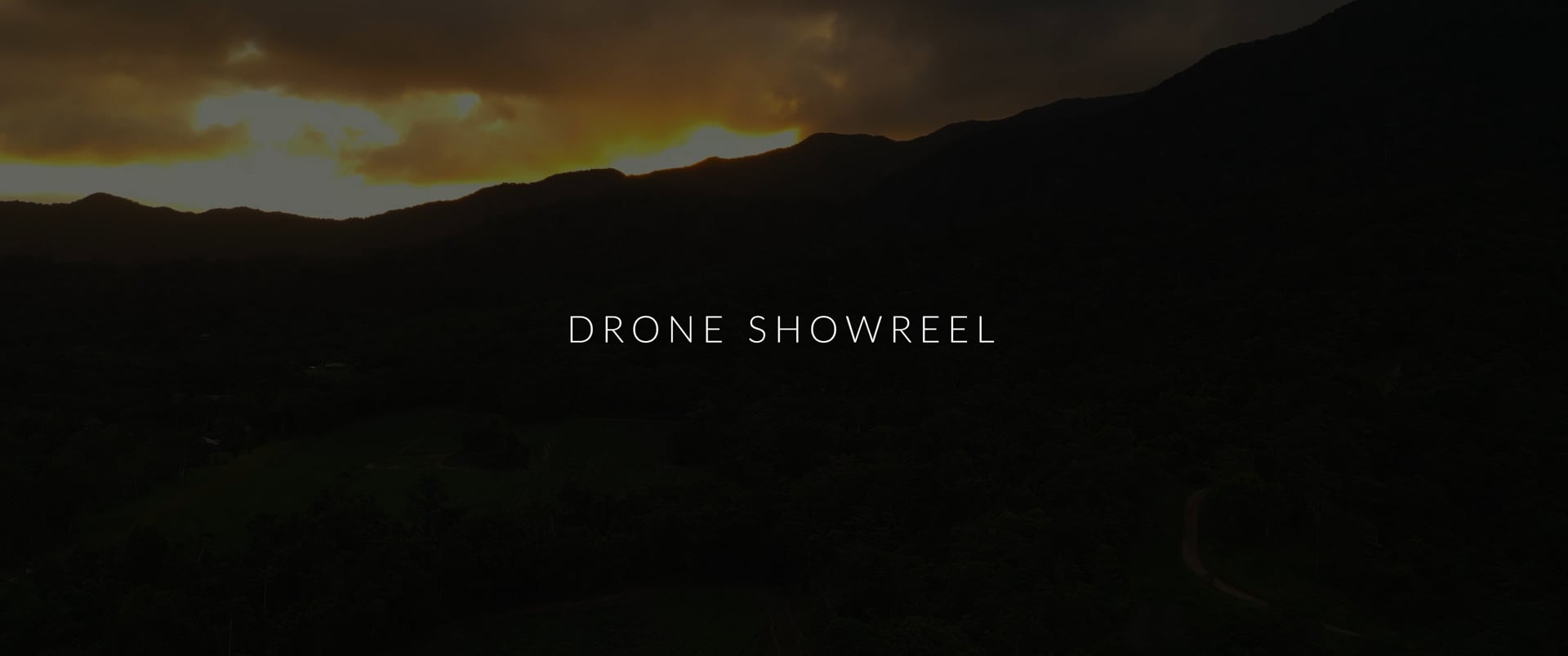 Mountain ridge at sunset from the air, the title card of Mustard's 2026 drone showreel