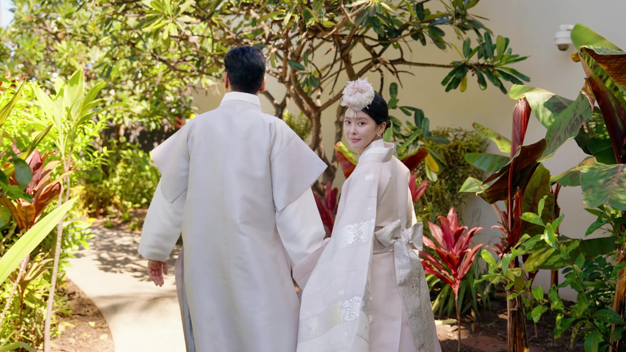 Jaein and Edward in their wedding clothes among tropical foliage