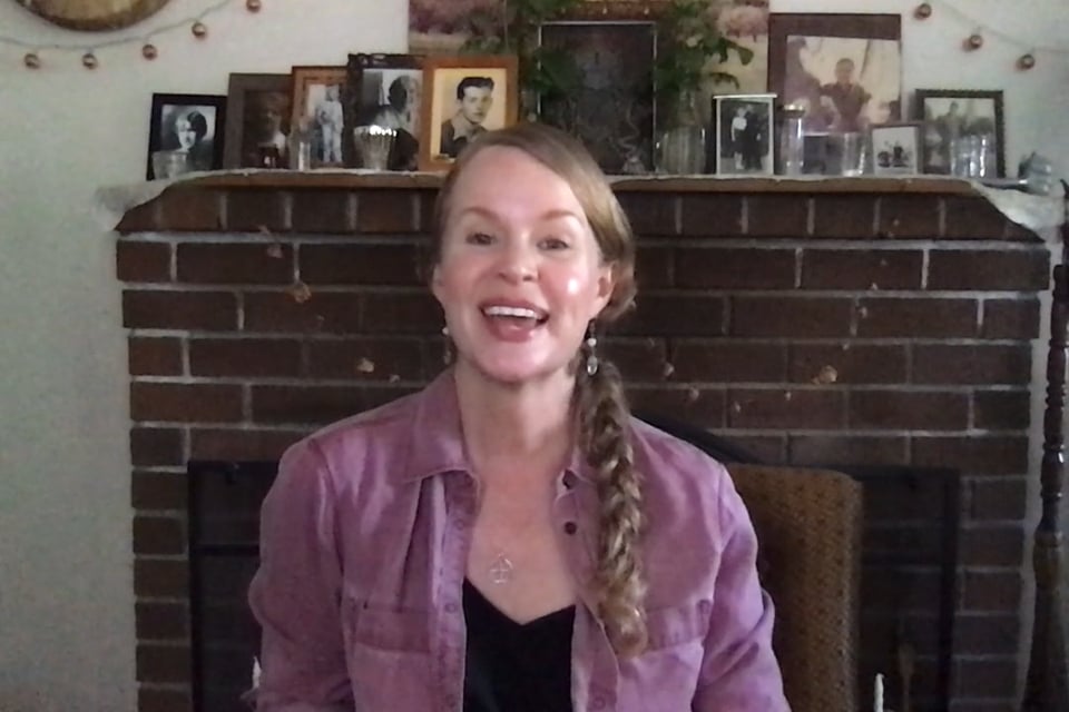 Lara in front of her altar with ancestor photos behind her.
