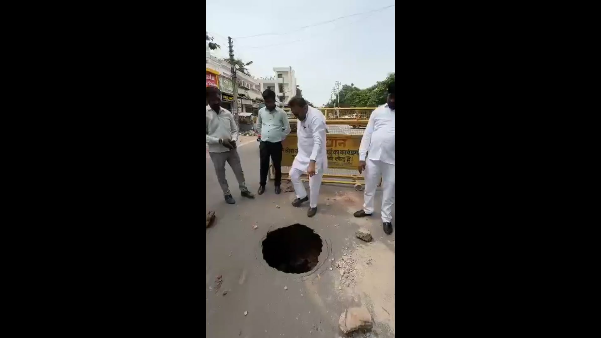 आगरा में समाजवादी पार्टी के नेता नितिन कोहली सड़क पर हुए गड्ढे में माल ढूंढ रहे हैं वह गड्ढे के पास बैठ जाते हैं और चारो