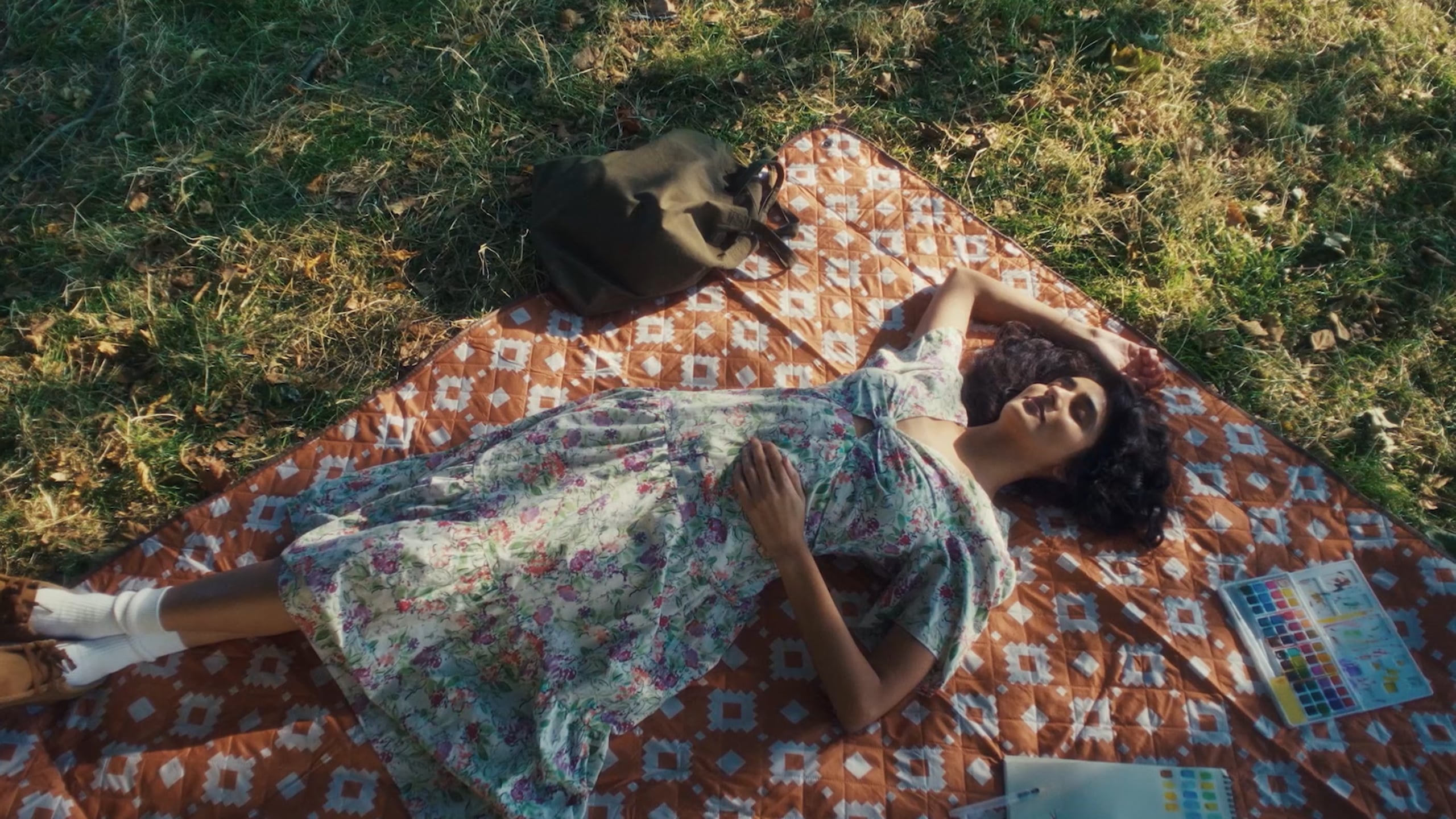 A resident and a dog on a picnic blanket in the gardens