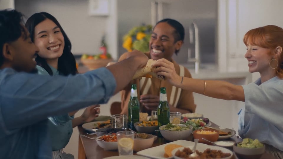 Friends sharing tacos and drinks around a dinner table