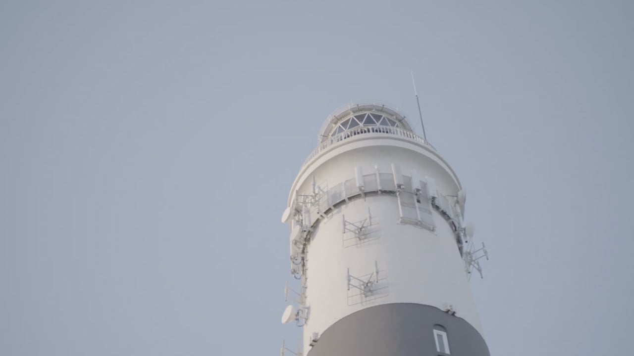 Turmspitze eines Sylter Leuchtturms vor grauem Himmel