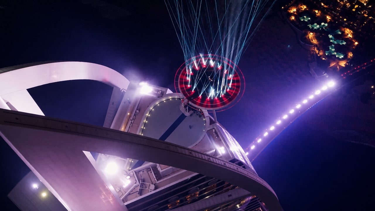 Still from the ChopperShoot cinematic showreel: the Burj Al Arab helipad lit up with lasers at night, seen from a drone