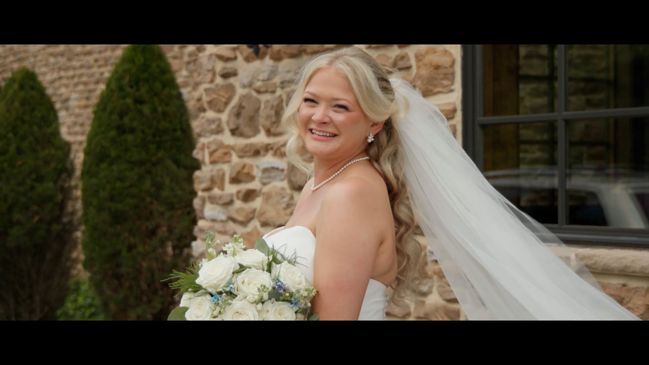 Bride smiling outside the stone winery at Folino Estate, from the TM Weddings wedding film