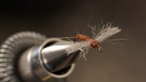 A fly vise holding a undefined after it is tied