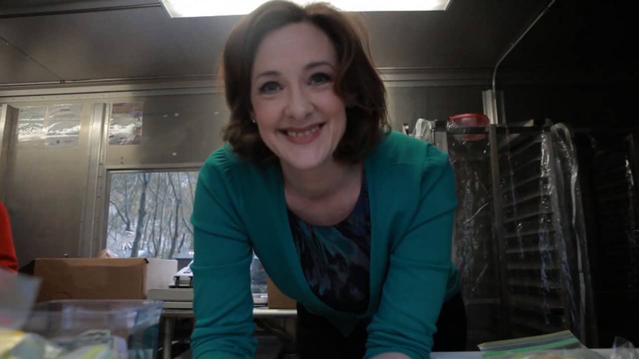 Joan Cusack in the Cupcakestop truck handing out cookies with glad to