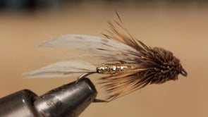 A fly vise holding a undefined after it is tied