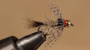 A fly vise holding a undefined after it is tied