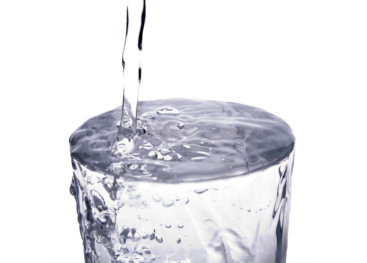 В стакан до краев налита вода. Переполненный стакан. Переполненный стакан с водой. Вода через край. Вода льется через край.
