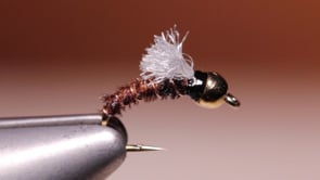 A fly vise holding a undefined after it is tied
